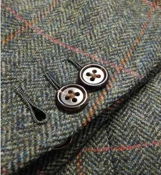 Photo of three handsewn buttonholes on herinbone twill fabric